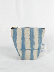 A blue and tan zipper pouch bag with a striped pattern. It is wide at the top and narrow at the bottom.