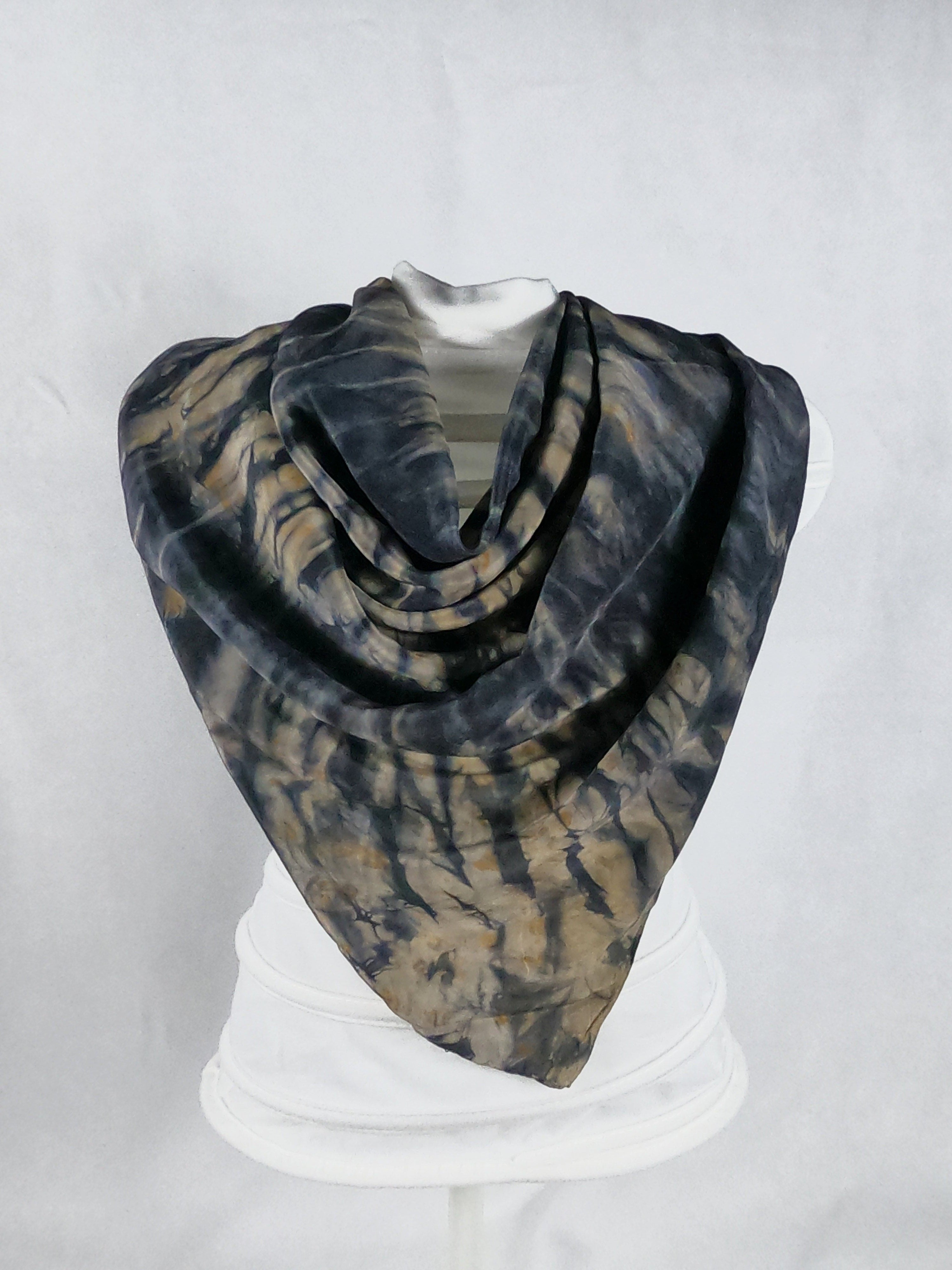 Square silk shawl styled on a mannequin. It has a dark navy and light brown ripple-like print.