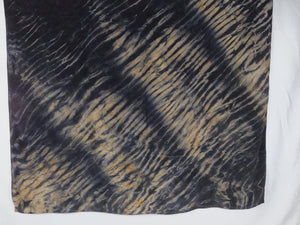 Square silk shawl laid flat. It has a dark navy and light brown ripple-like print.